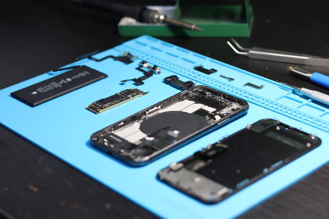our-services-3 Disassembled smartphone with tools on a workbench, emphasizing repair and technology.